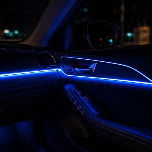 Blue SkyGlow fibre optic light line running along a car door panel and armrest at night